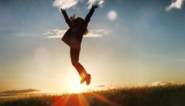 Woman jumping with sun